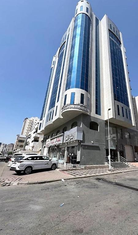 a large building with a car parked in front of it at فندق مواسم العزيزية in Al ‘Azīzīyah