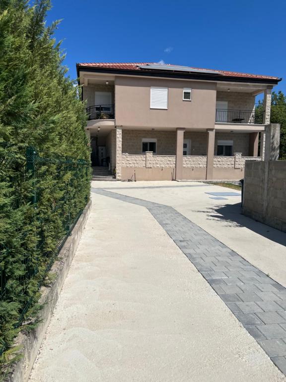a house with a sidewalk in front of a building at DIS LUX Apartments in Radanovići