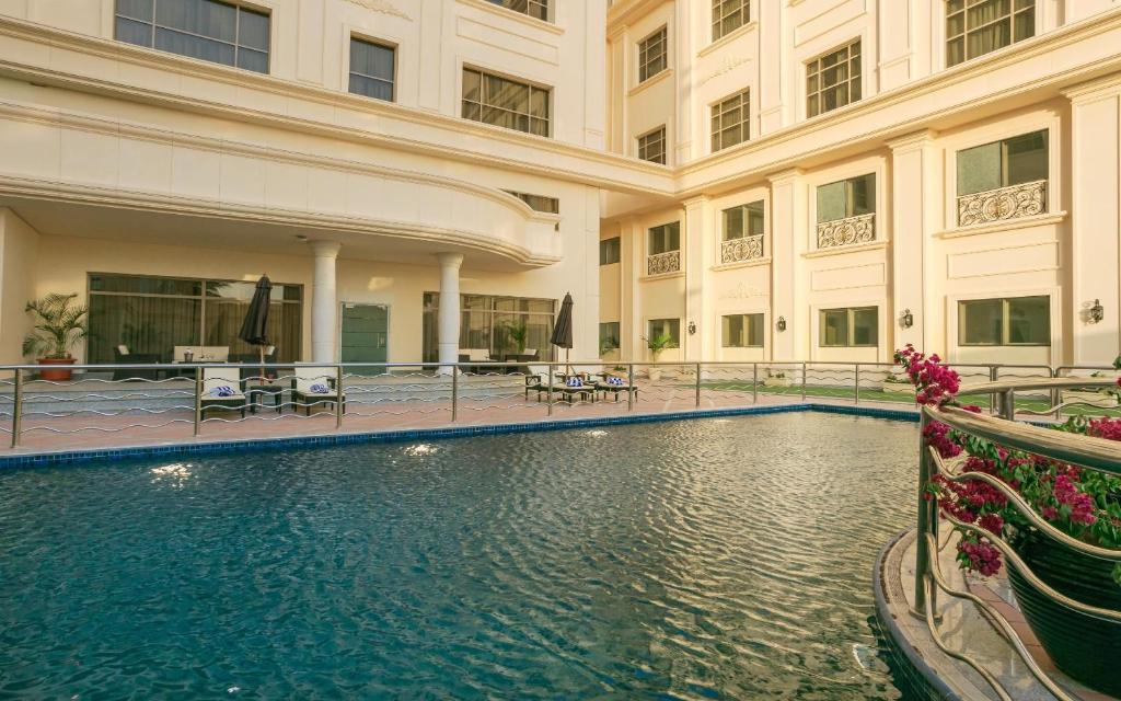een groot gebouw met een zwembad ervoor bij Sunset Jeddah in Jeddah