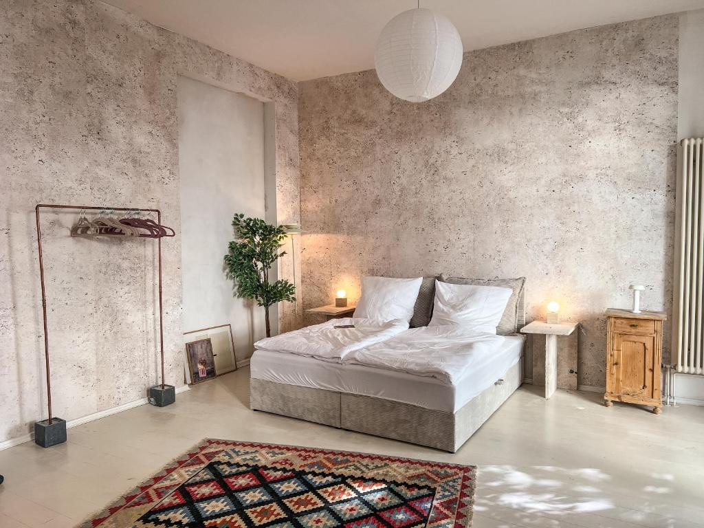 une chambre avec un lit et un mur en béton dans l'établissement Loft-style design apartment in the heart of Berlin, à Berlin