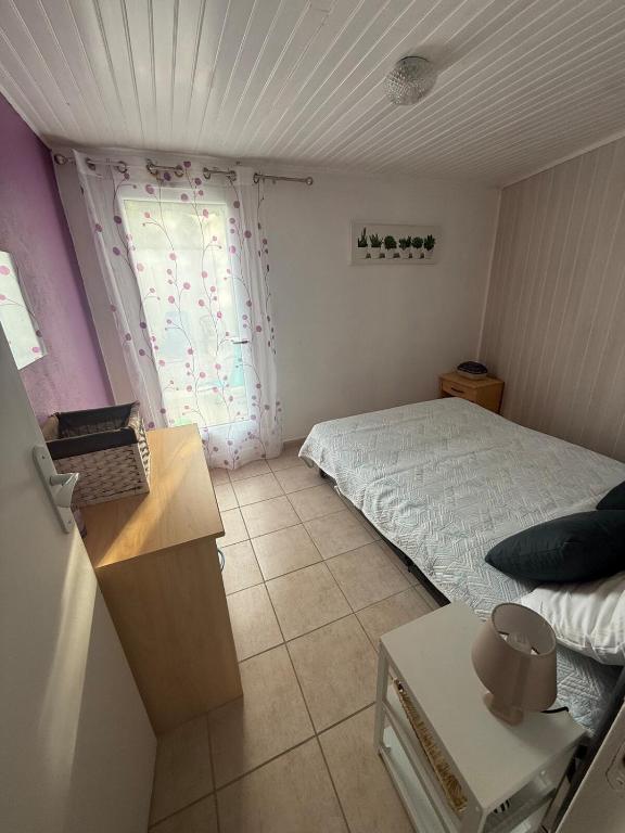 a small bedroom with a bed and a window at Maison familiale la Parée in Bretignolles-sur-Mer