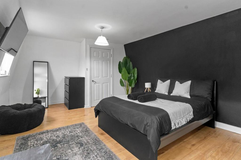 a bedroom with a large bed and a black wall at Large Delux Studio - 26 in Leicester