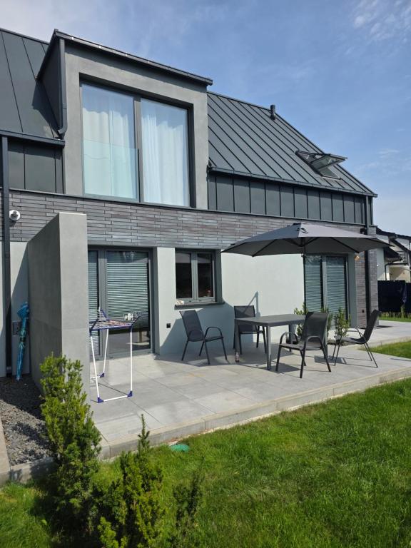 una casa con patio con tavolo e ombrellone di Marina Dziwnow Premium Haus a Dziwnów