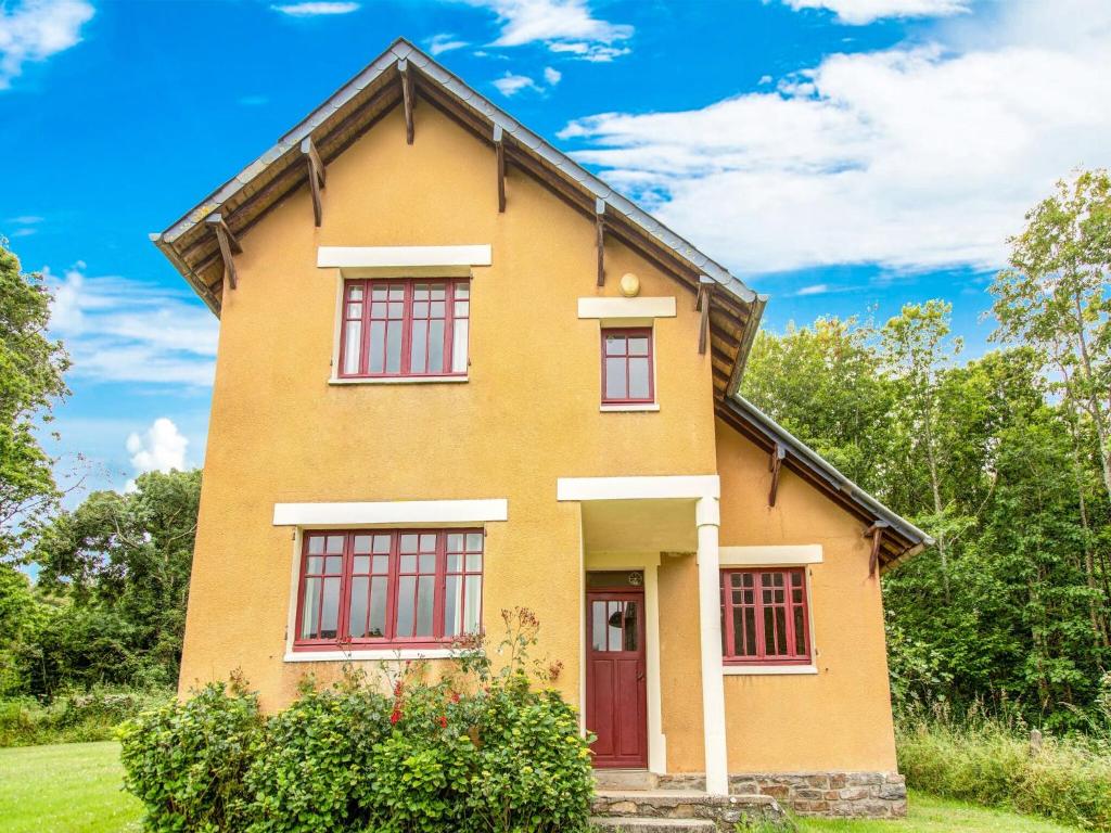 a yellow house with a red door at Elegant Normandy Escape in Portbail