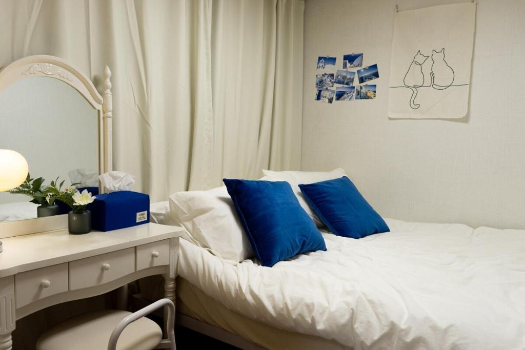 a bedroom with a bed with blue pillows and a desk at Air conditioner 4 people Line 2 Sillim Station Parking Outdoor table Seoul tour Gocheok Dome K-pop lovers' hideout in Seoul