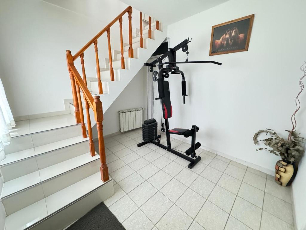 a gym room with a treadmill and stairs at Brisas, Departamento Temporario en Puerto Madryn in Puerto Madryn