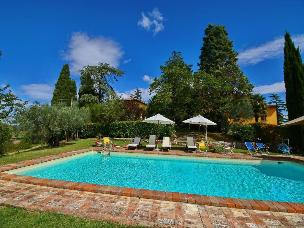 a swimming pool with chairs and umbrellas in a yard at Farmhouse in Todi with Pool & Theater Nearby in Chioano