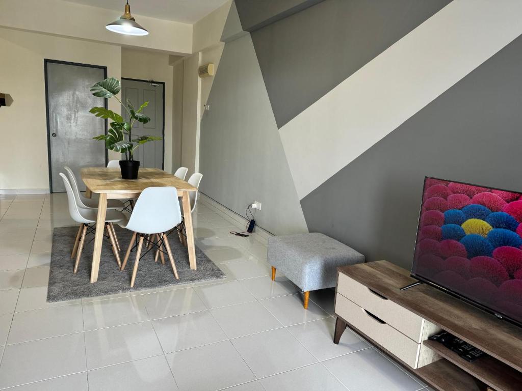 a living room with a table and chairs and a tv at Damai Vacation Stay 7 pax 3 Free Parking in Shah Alam