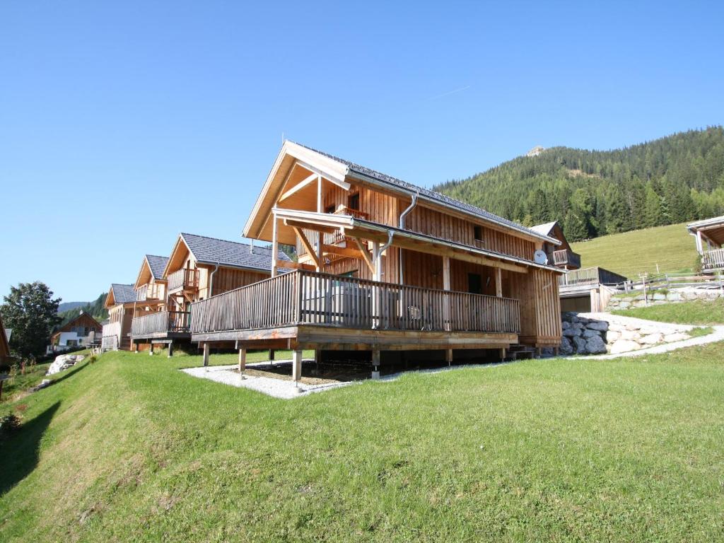a large wooden house on top of a grassy field at Chalet in Hohentauern am Skilift in Hohentauern