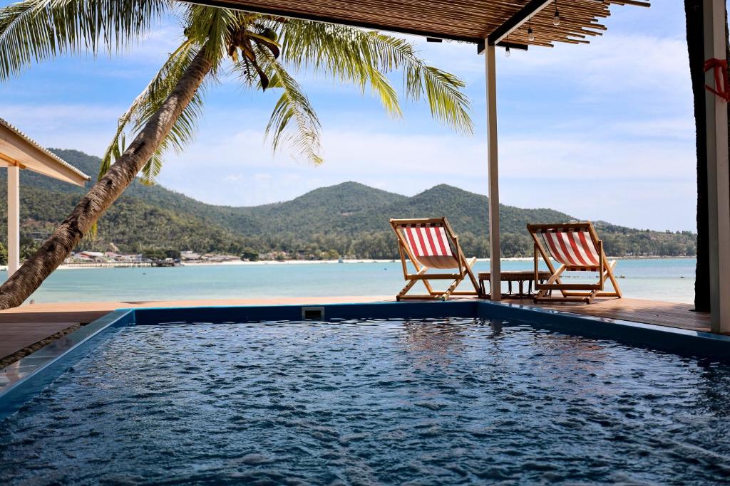 twee stoelen en een zwembad met uitzicht op de oceaan bij Beachfront 2BR Villa w Private Pool in Ko Pha Ngan