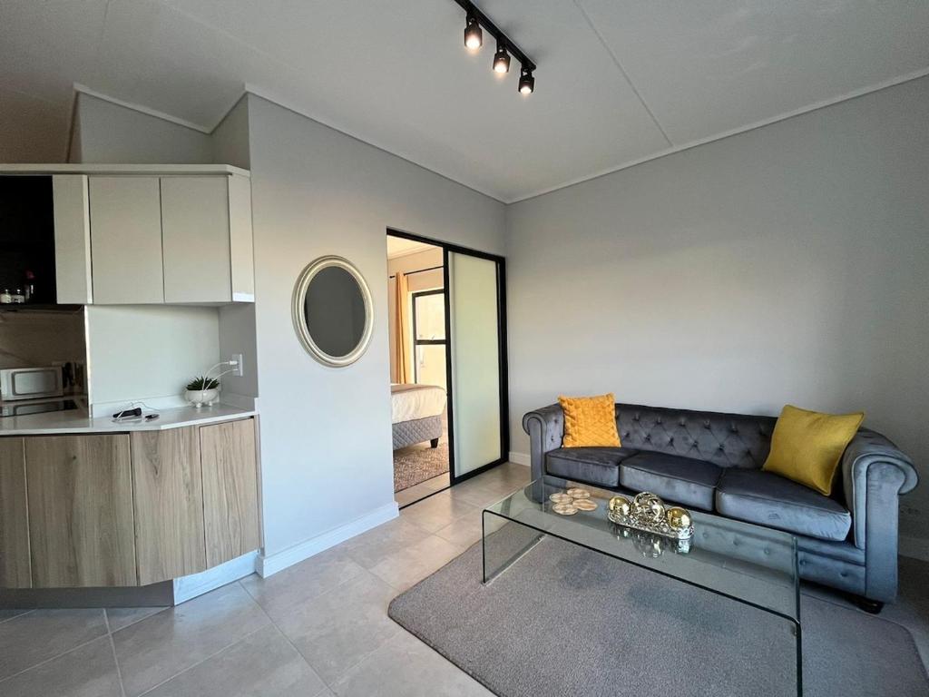 a living room with a couch and a table at AlimamaSpaces The Chelsea's Munyaka in Midrand