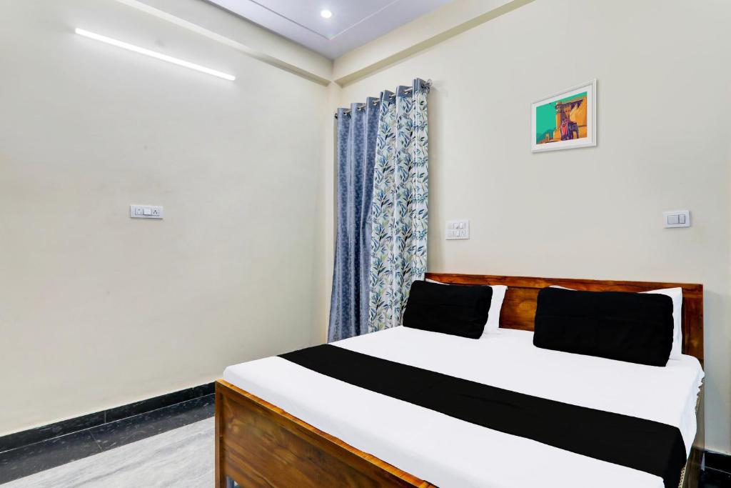 a bedroom with a bed and a window at Hotel O Heaven Inn in Lucknow
