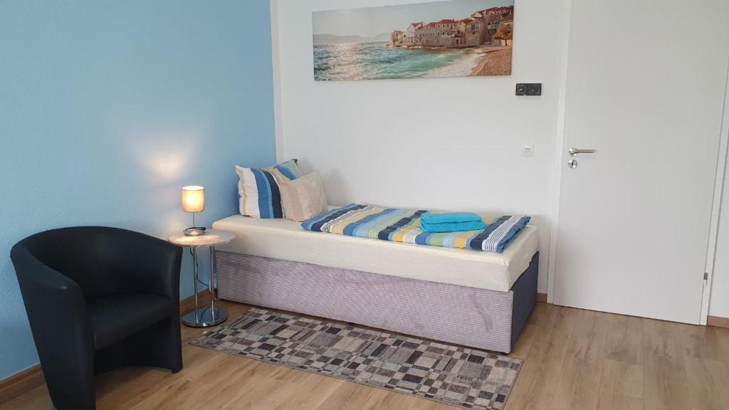 a small bedroom with a bed and a chair at Die ideale Wohnung für 2 Personen in Solingen