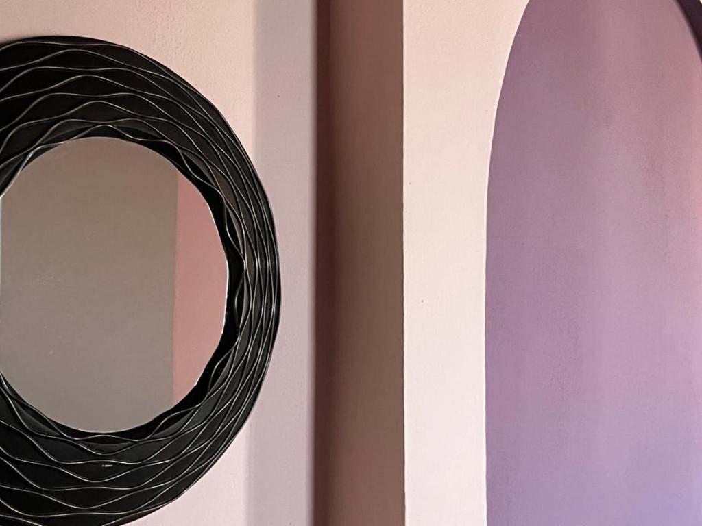 een spiegel aan een muur naast een paarse muur bij City Centre Rooms 4R in Shkodër