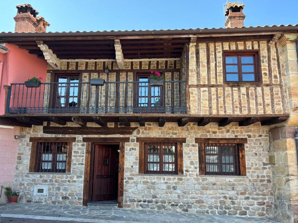 an old stone building with a balcony on top at El Limonero in Arenas de Iguña