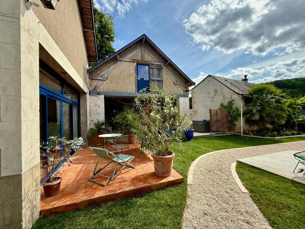 - une terrasse en bois avec une table et une chaise dans la cour dans l'établissement la Maison sous les Arbres - Duplex, jardin et spa, à Pocé-sur-Cisse