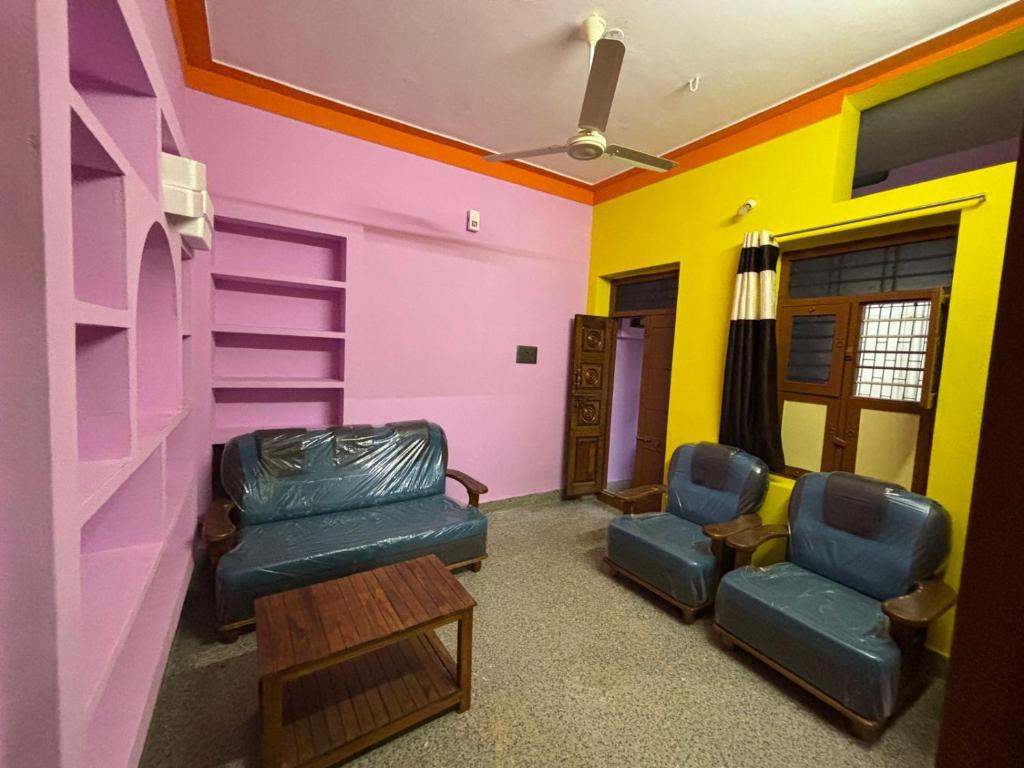 a room with two chairs and a colorful wall at M S , Homes in Tiruvannāmalai