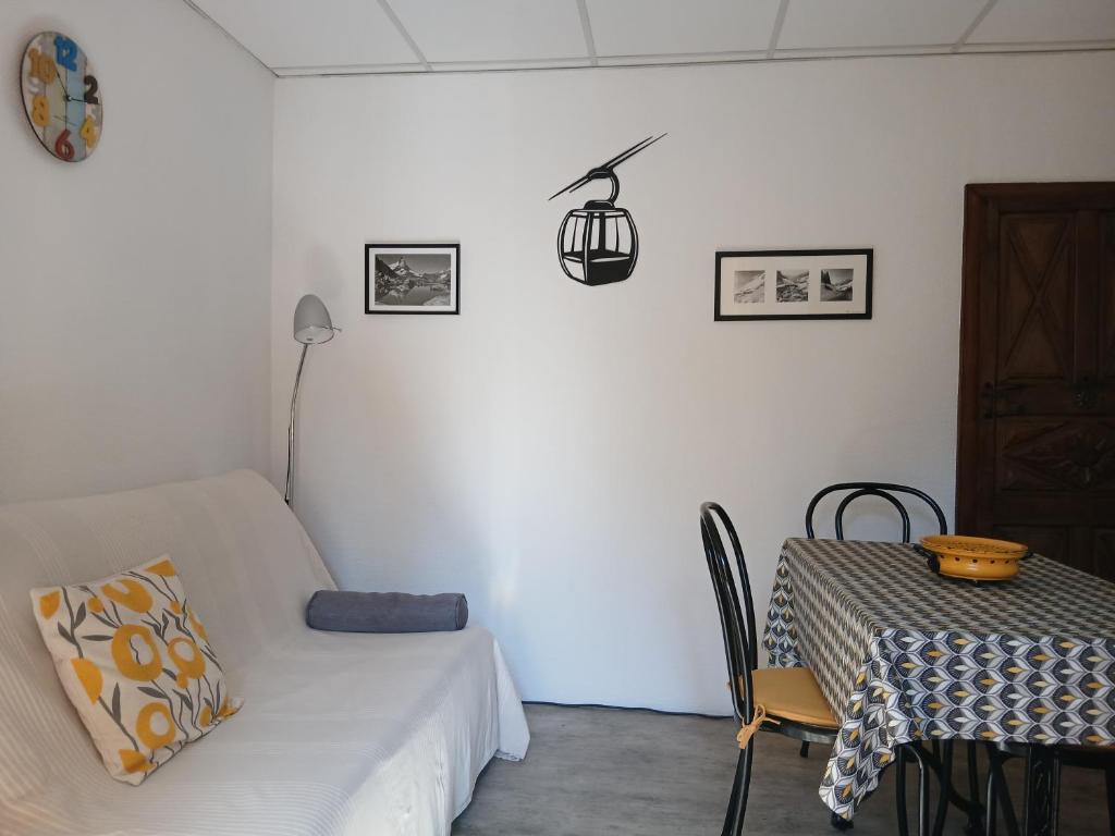 a white room with a table and a couch and a table and chair at Le Som' des Pyrénées in Luz-Saint-Sauveur