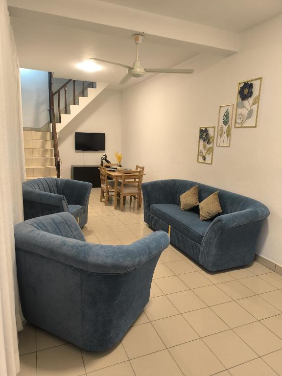 a living room with two blue couches and a table at DK Lodge in Kandy