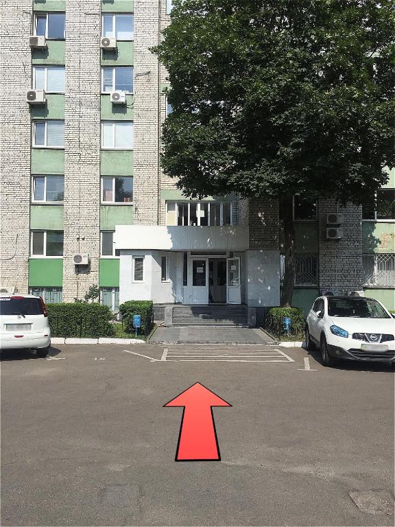 a red arrow in a parking lot in front of a building at Hotel Trias in Kyiv