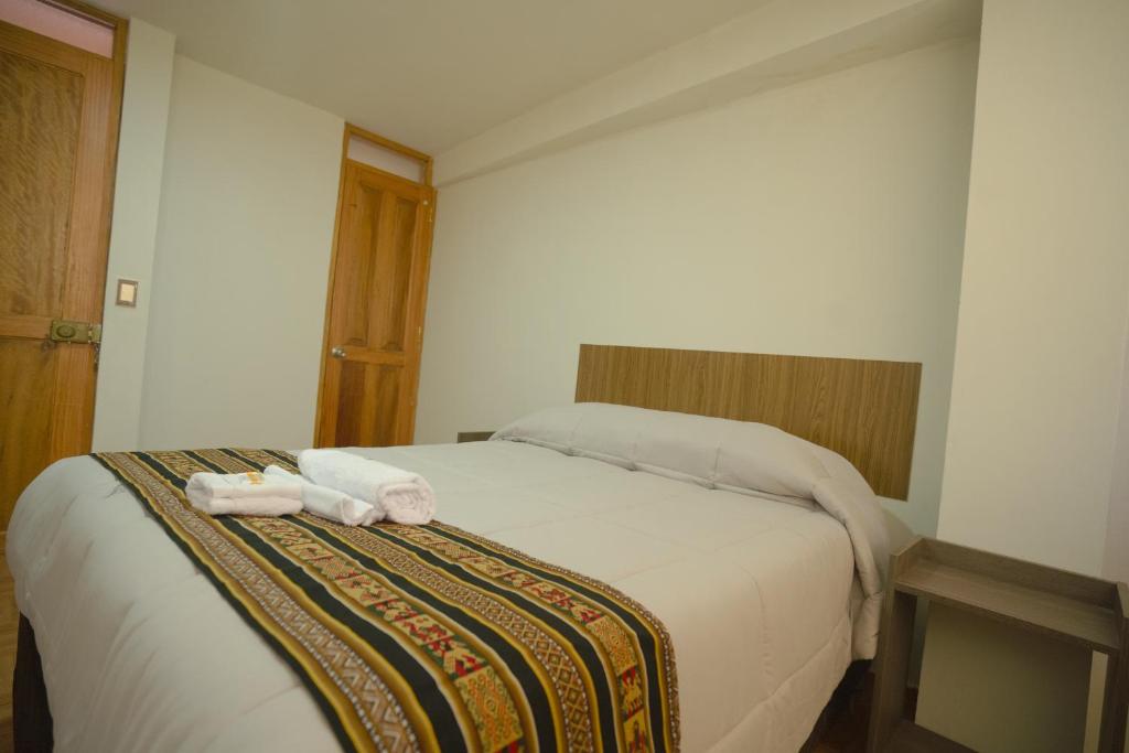 a bedroom with a bed with towels on it at Refugio Sagrado Boutique in Ollantaytambo