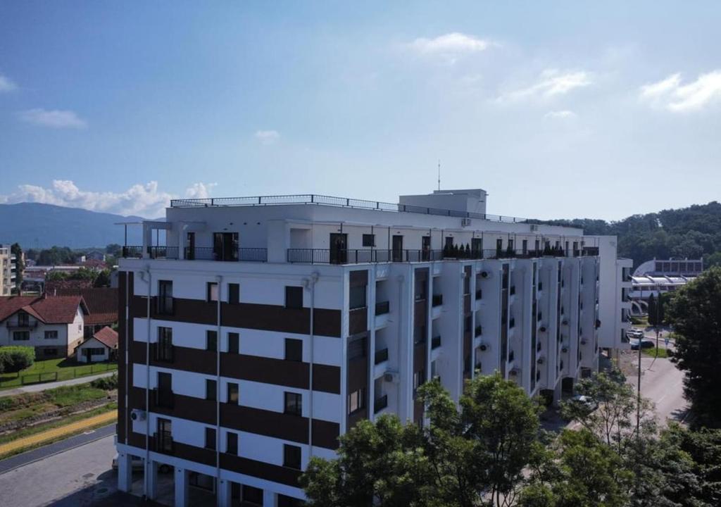 ein weißes Gebäude mit schwarzen Fenstern darüber in der Unterkunft DZL - Apartman Nina in Vrnjačka Banja