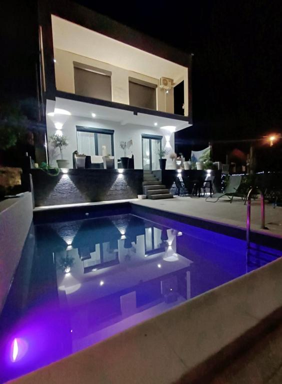 a swimming pool in front of a house at night at Private Villa with Pool - Utjeha Hills in Utjeha