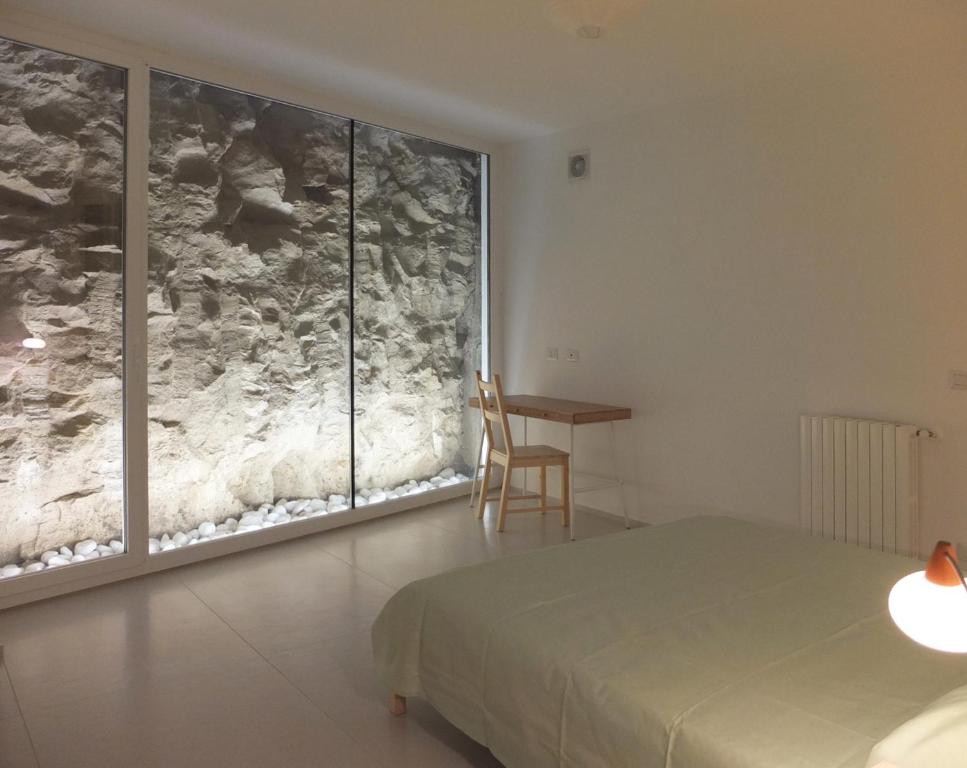 una camera con un letto e una grande finestra di La Timpa a Ragusa