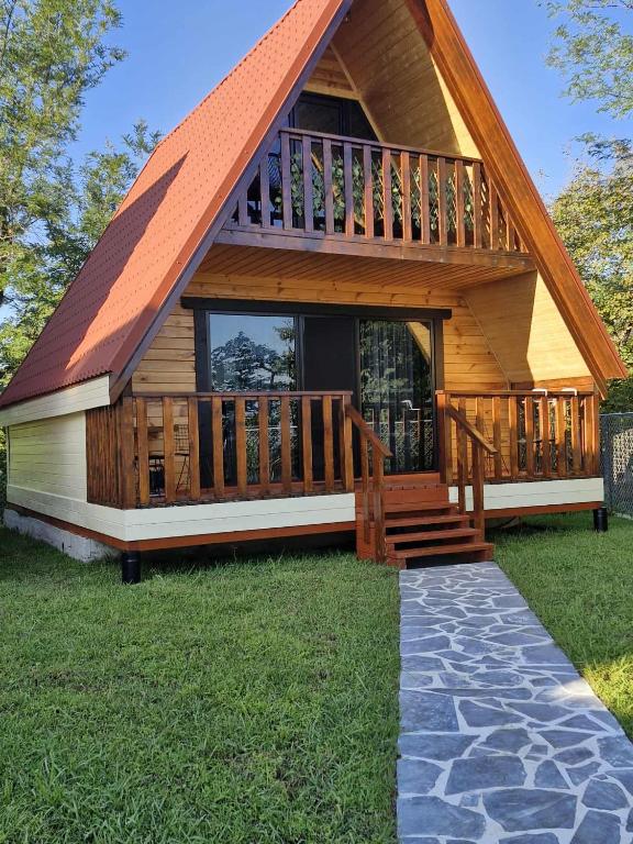 a large wooden cabin with a large deck at Cozy Cottage B in Kutaisi