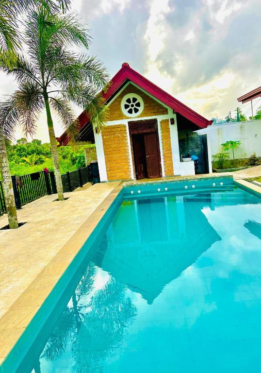 a house with a swimming pool in front of a house at SAMA KAMI Ayurvedic Resort & Villa in Polatupalata