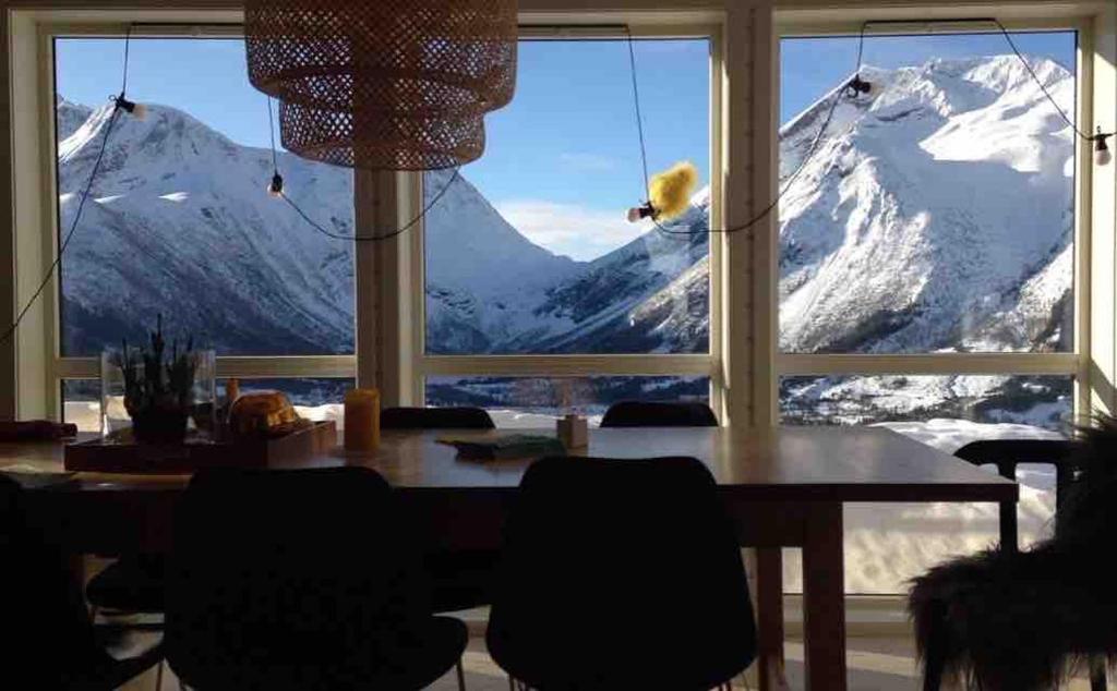 a dining room table with a view of a snow covered mountain at Great cabin in beautiful nature in Ørsta