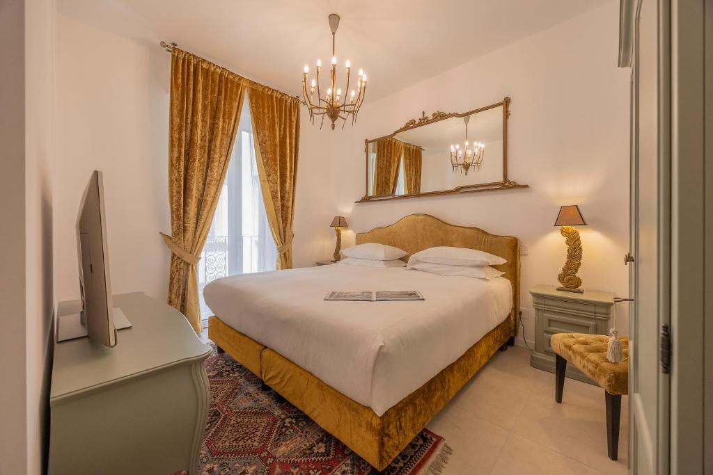 a bedroom with a bed and a desk and a mirror at Corte Realdi Suites Arena in Verona