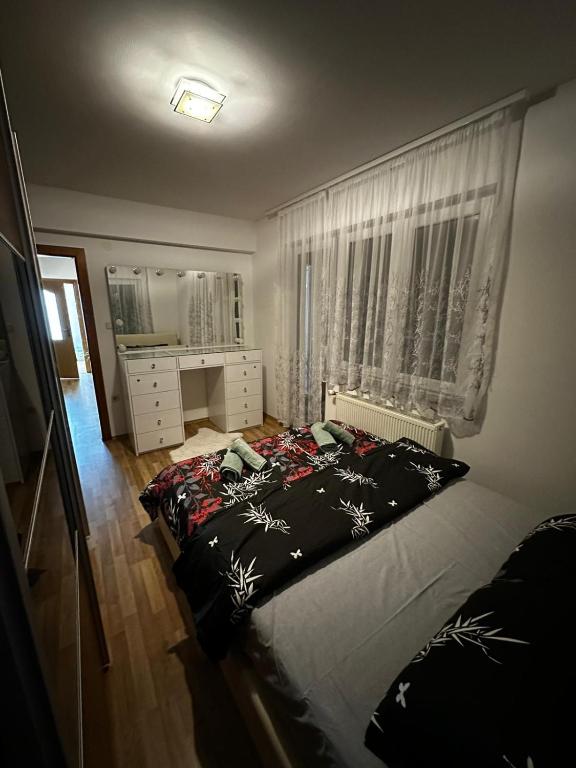 a bedroom with a large bed and a window at Beauty Room Apartman in Prnjavor