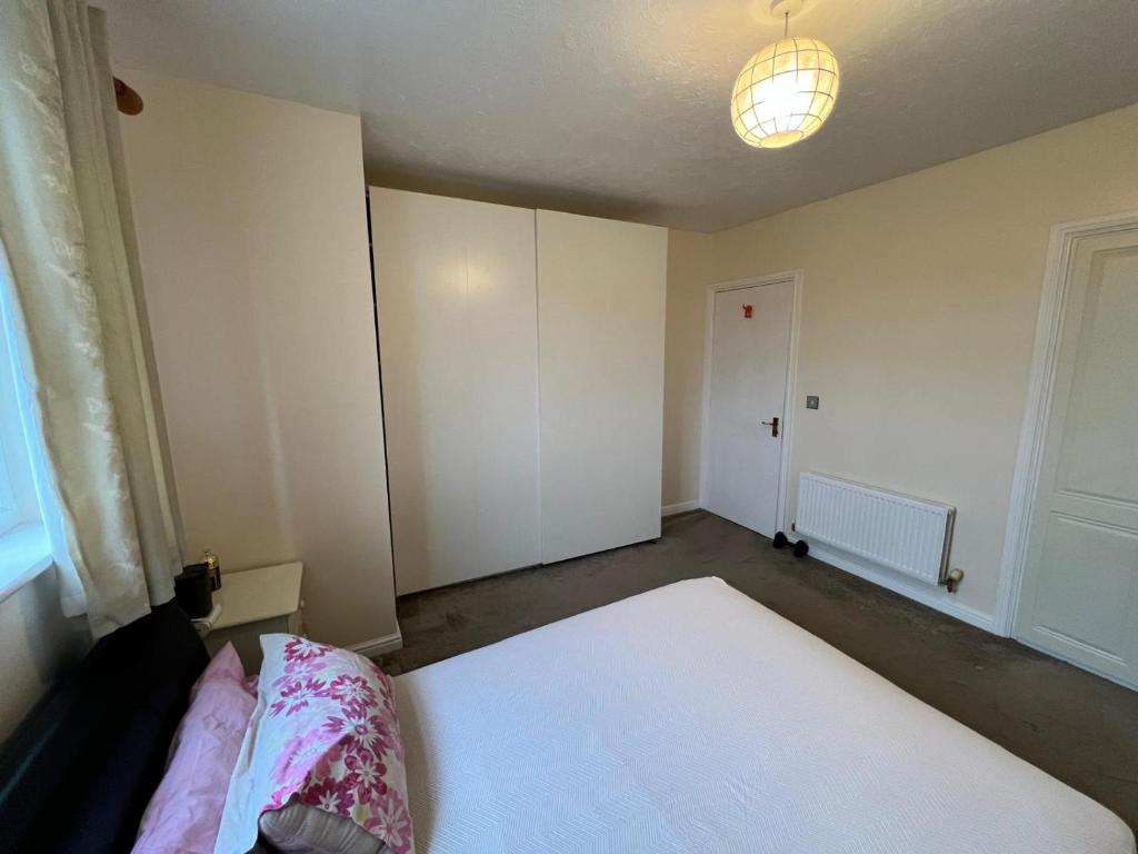 an empty room with a bed and a light at Premium Double Bed in Shared House in North Stifford