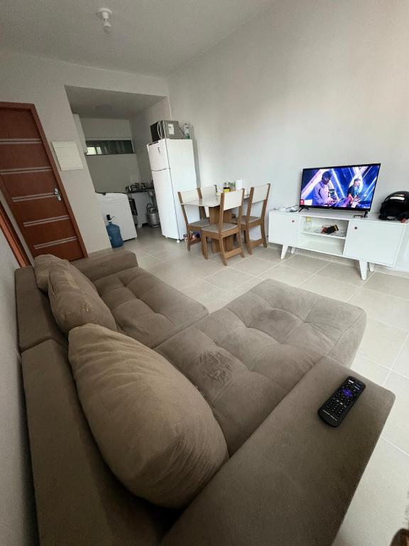 een woonkamer met een bank en een televisie bij Apartamento mobiliado com piscina in Ananindeua