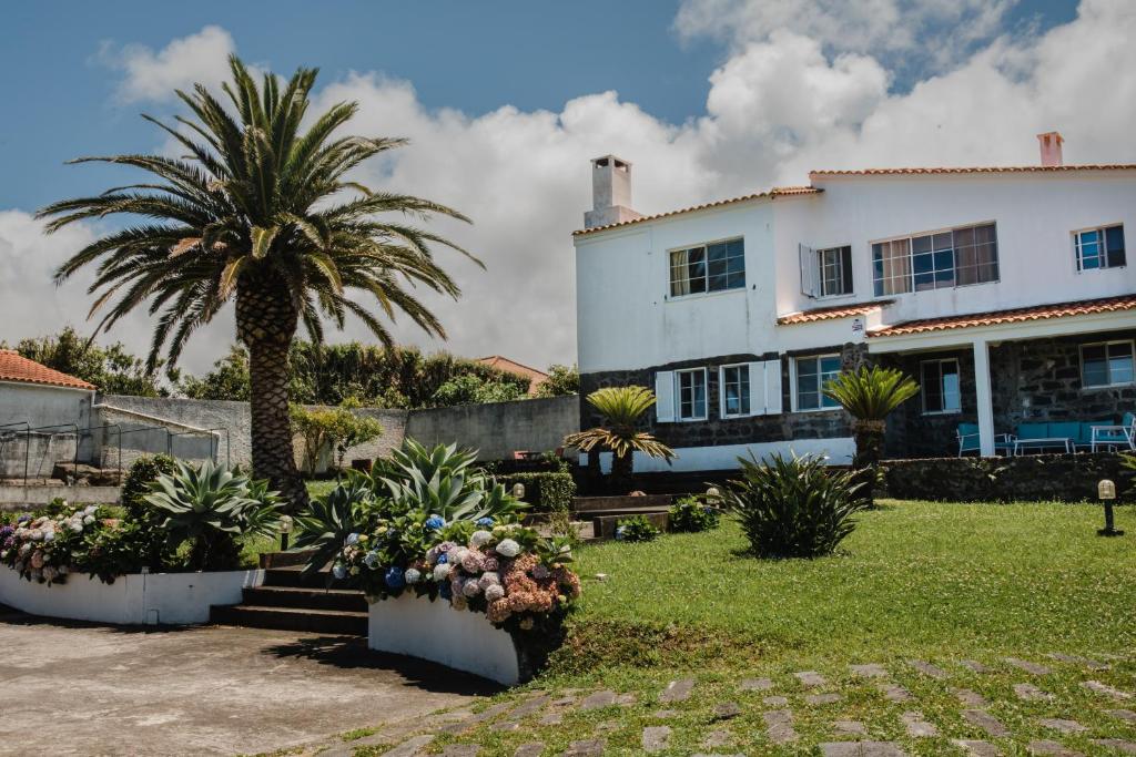 ein großes weißes Haus mit Palmen und Pflanzen in der Unterkunft Ocean View Villa Retreat Quinta do Sol in Rabo de Peixe