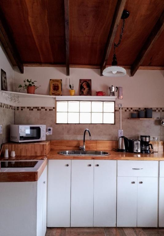 a kitchen with white cabinets and a sink at Casa Montanara in El Chalten