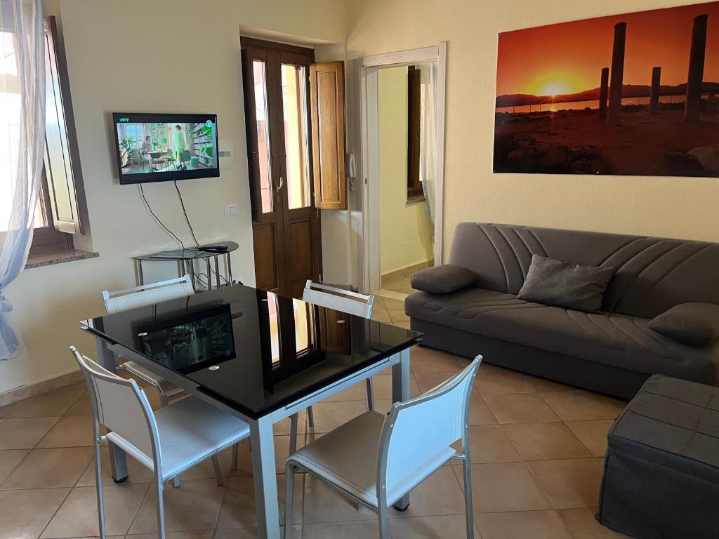 a living room with a couch and a table and chairs at Casa Vacanze Donna Giovanna in Pula