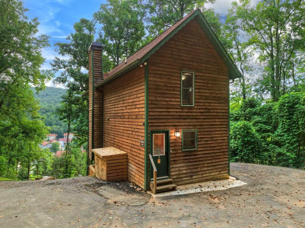 a small wooden house with a door on a hill at New Mtn&City Views Hot Tub Sauna Arcade Pool in Helen