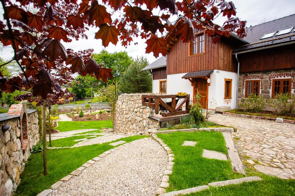 a house with a stone pathway in front of a yard at Apartamenty Batur in Karpacz