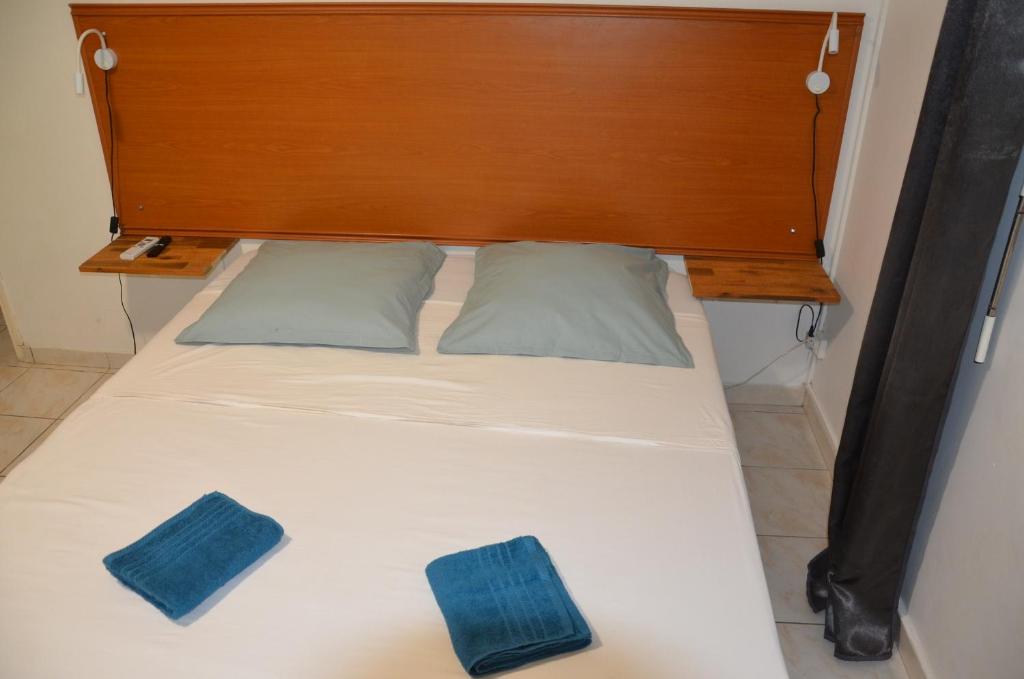 a bed with a wooden headboard and two pillows at Sweet Mangot in Gros-Morne