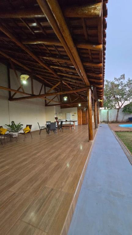 a large room with a wooden floor with tables and chairs at Rancho Petite Fleur in Aparecida do Taboado