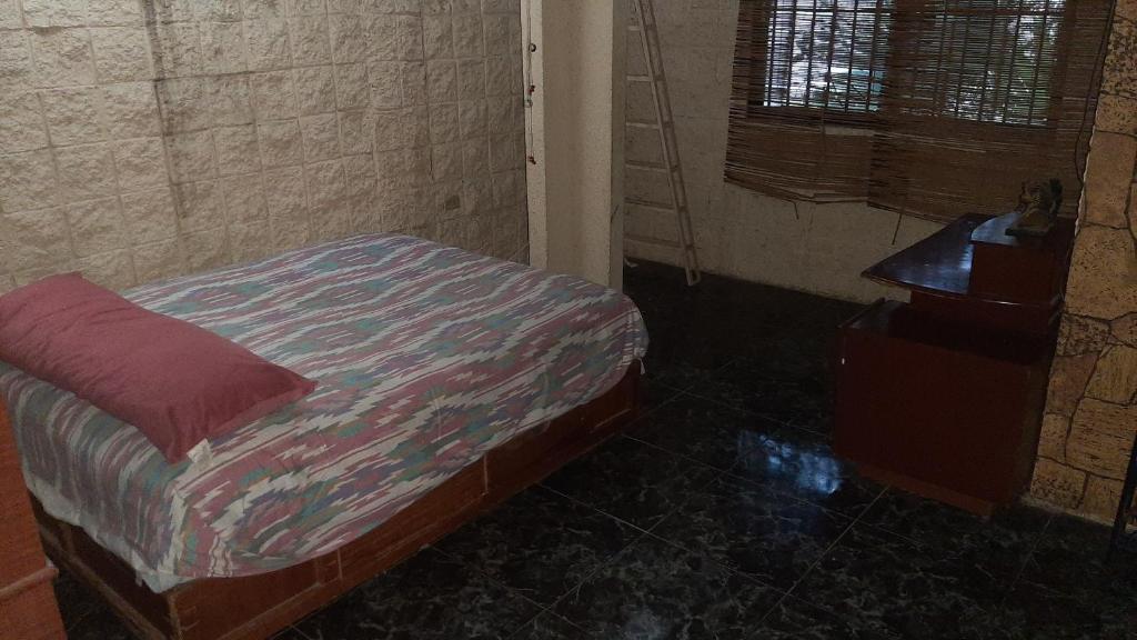 a small bedroom with a bed and a table at Castillo de Mario in Cancún
