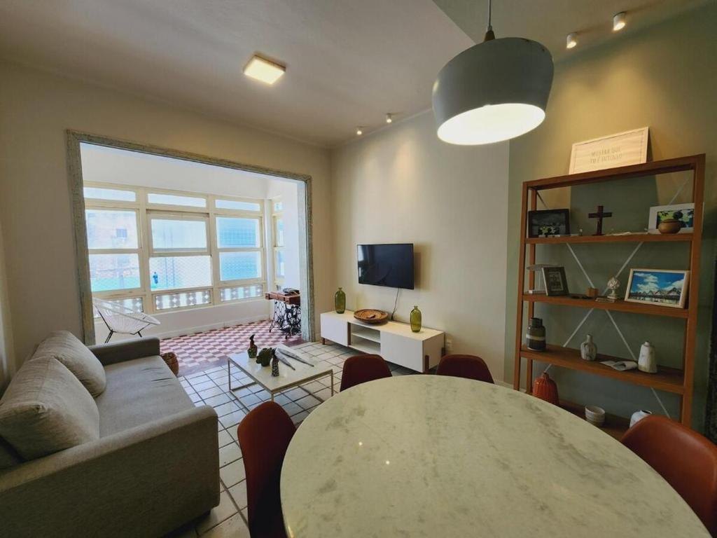 a living room with a table and a couch at Historico Edf Oceania in Boa Viagem in Recife