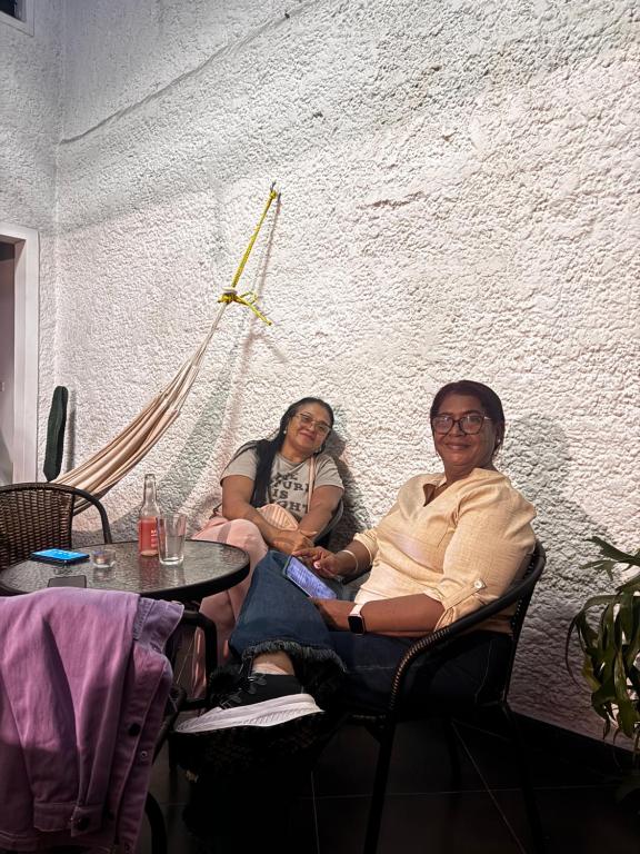 two women sitting in chairs at a table at Hostal Galería de la Montaña, Medellin in Estación El Salto