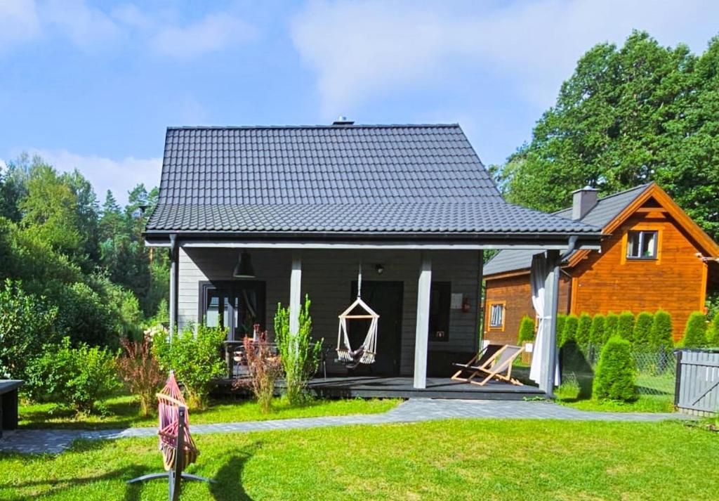una casa en un patio con césped en Leśne Klimaty, en Marózek