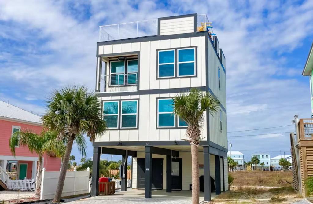 a building with palm trees in front of it at Happy Ours in Mexico Beach
