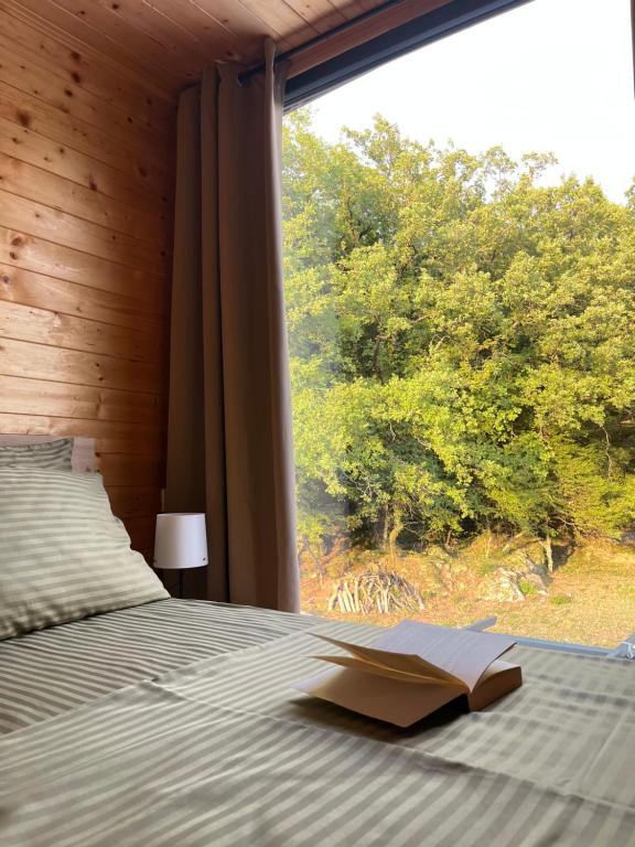 a book laying on a bed in a room with a window at Madera House in Herceg-Novi