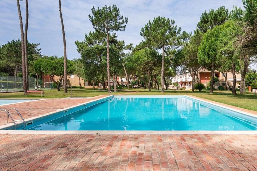 a swimming pool with blue water in a park at Ofir Nature Stay in Fão