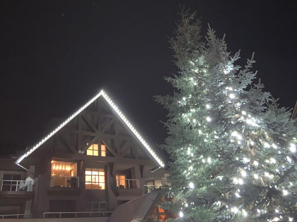 Un árbol de Navidad delante de una casa por la noche en XL Luxury Penthouse Ski-in Ski-out The Aspens, en Whistler